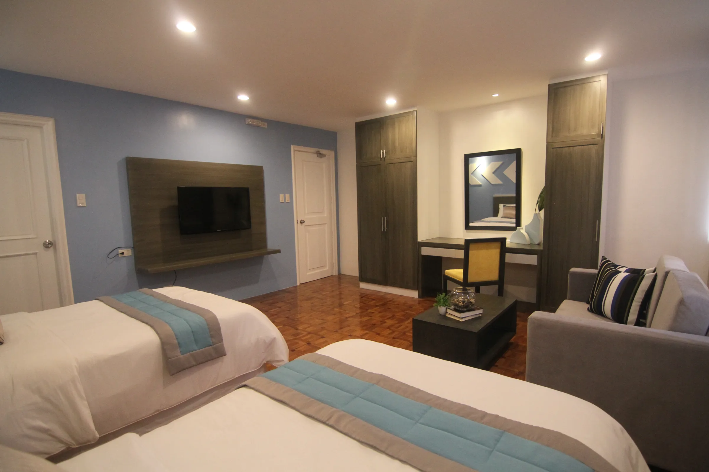 The Deluxe Twin room's TV wall, wardrobe and vanity.